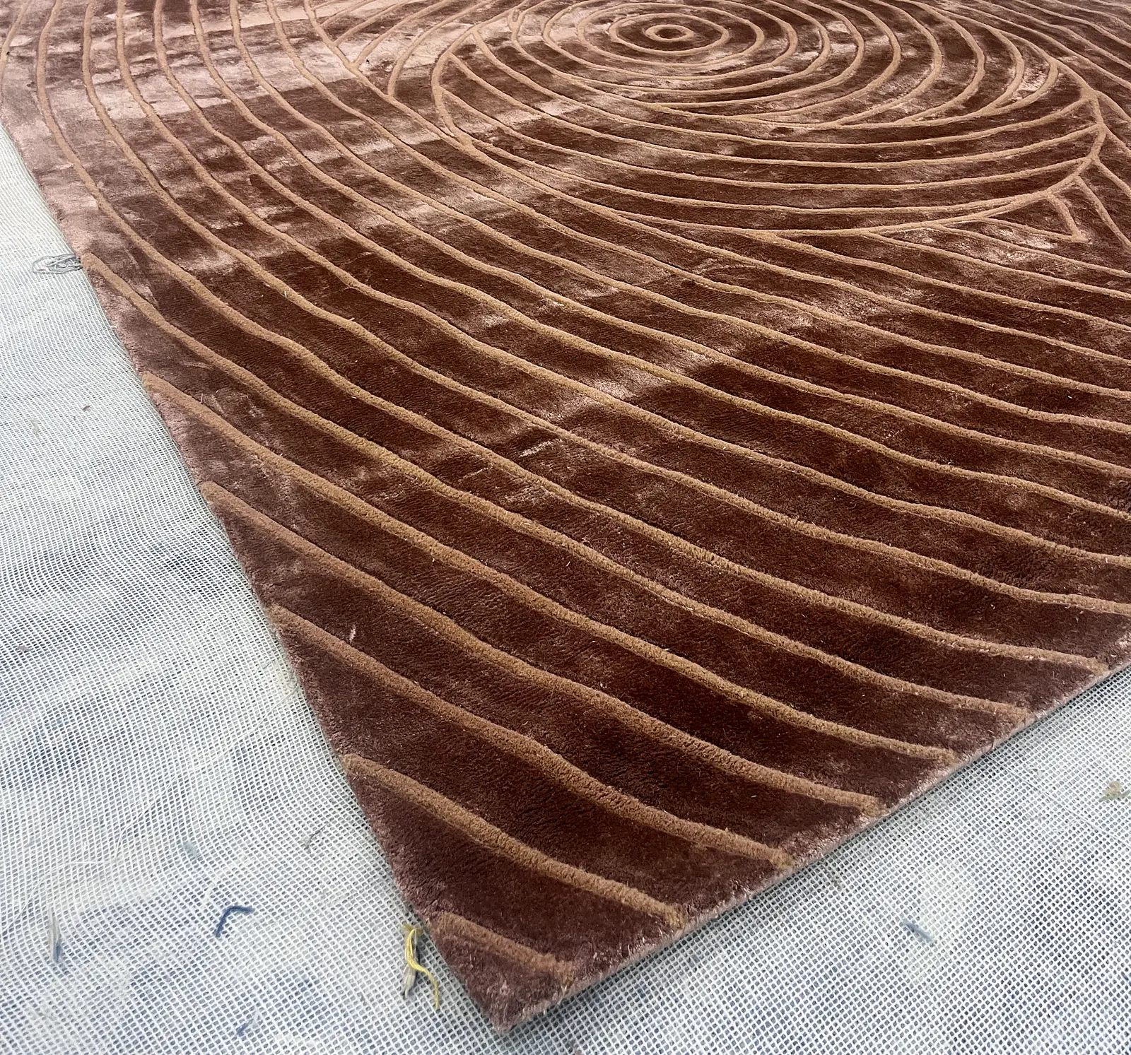 A carved spiral rug pattern viewed from an angle, showing pile depth