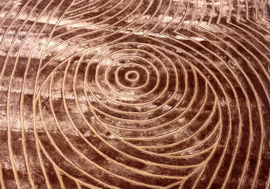 Carved spiral pattern in a rose-bronze rug